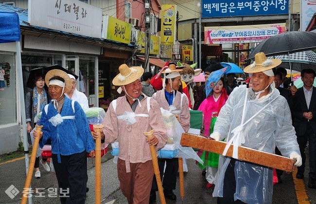 ▲  ‘보부상, 문화를 입히다’행사가 열린 27일 부여 중앙시장에서 풍물패를 동반한 보부상들이 저산팔읍 보부상단 길쌈놀이를 재현하고 있다. /박갑순 부장