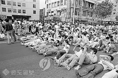 ▲ 6.10 항쟁 국민대회
<br />서울 종로3가에서 호헌철폐 독재타도 반정부 구호를 외치며 학생들이 거리에 드러누워 농성 하고 있다. 1987.6.18/출처=연합 DB ▲ 6.10 항쟁 국민대회
<br />서울 종로3가에서 호헌철폐 독재타도 반정부 구호를 외치며 학생들이 거리에 드러누워 농성 하고 있다. 1987.6.18/출처=연합 DB