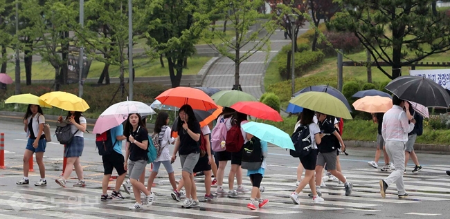 ▲장마 영향으로 비가 내리면서 부산 남구에 있는 횡단보도에서 시민과 학생들이 우산을 쓰고 걸어가고 있다. 연합뉴스