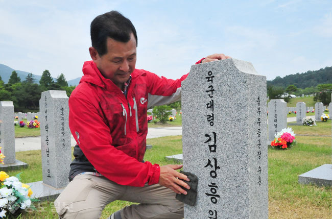 ▲대전국립현충원에서 만난 김병한씨가 아버지의 묘비를 닦고 있다. 