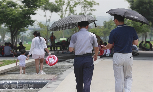 ▲ 무더운 날씨를 보인 12일 오후 서울 여의도 한강공원에서 시민들이 우산으로 햇빛을 가리고 있다./연합뉴스