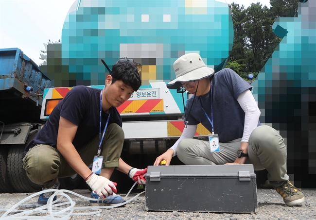 ▲24일 부산 남구에 있는 한 화물차 주차장에서 부산시보건환경연구원 직원이 탱크로리 차량에서 시료를 채취하고 있다. 부산시보건환경연구원은 해안을 따라 가스 냄새가 퍼진 지난 21일 오후 5시 30분을 전후로 광안대교를 통과한 탱크로리 차량 4대에서 시료를 채취해 분석하고 있다. 연합뉴스
