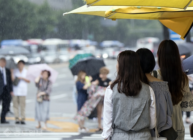 ▲ 중부지방에 비가 내린 27일 오후 서울 광화문광장에서 우산을 가져오지 않은 시민들이 횡단보도에서 비를 피해 서 있다./연합뉴스