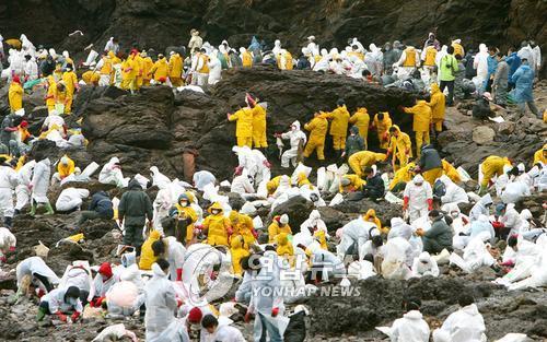 ▲ 기름유출 피해 당시 자원봉사에 나선 사람들/사진=연합 DB ▲ 기름유출 피해 당시 자원봉사에 나선 사람들/사진=연합 DB