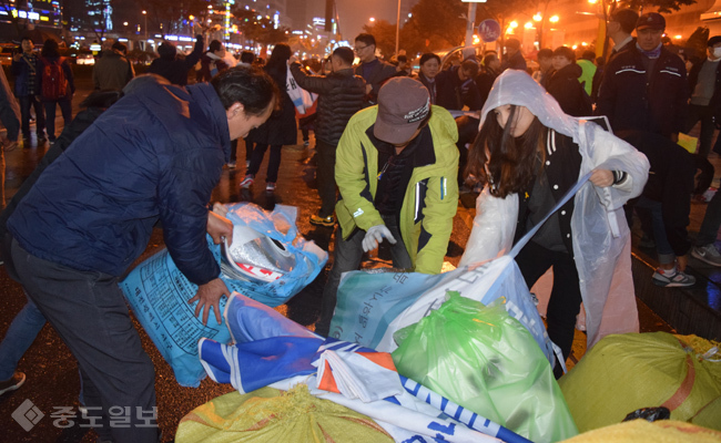 ▲ 행사 종료 후 참가자들과 자원봉사자들이 집회에 사용된 피켓과 집기류를 정리하고 있다. 