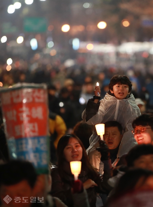 ▲ 2016년, 아이의 기억
<br />제5차 민중총궐기대회가 열린 11월 26일 밤 서울 청와대 인근 정부청사 창성동 별관 앞에서 한 어린이가 아빠 어깨에 올라타 구호를 외치고 있다./연합 ▲ 2016년, 아이의 기억
<br />제5차 민중총궐기대회가 열린 11월 26일 밤 서울 청와대 인근 정부청사 창성동 별관 앞에서 한 어린이가 아빠 어깨에 올라타 구호를 외치고 있다./연합