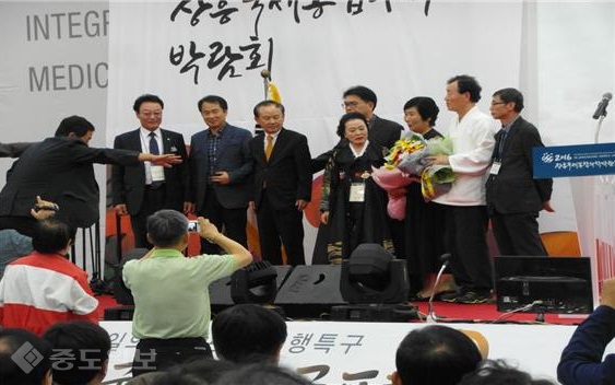 ▲ 지난 10월 전남 장흥 문학특구 행사장 무대에서 한승원 소설가에게 꽃다발을 전하는 김정 시인.