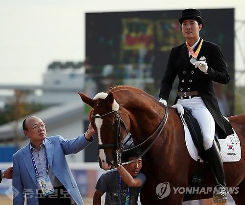 ▲ 2014년 9월 23일 인천 드림파크 승마장에서 한화그룹 김승연 회장(왼쪽)이 2014 인천 아시안게임 승마 마장마술 개인전에서 은메달을 획득한 아들 김동선의 말을 쓰다듬고 있다./사진=연합DB ▲ 2014년 9월 23일 인천 드림파크 승마장에서 한화그룹 김승연 회장(왼쪽)이 2014 인천 아시안게임 승마 마장마술 개인전에서 은메달을 획득한 아들 김동선의 말을 쓰다듬고 있다./사진=연합DB
