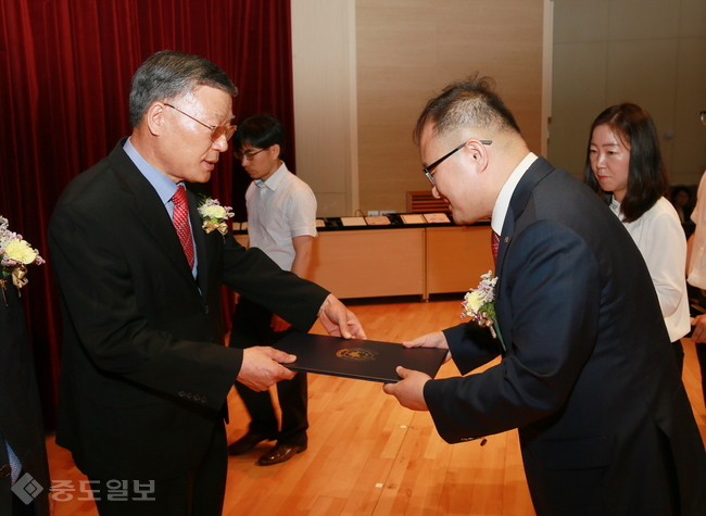 ▲ 지난달 30일 열린 충남도교육청 2017년도 상반기 퇴임 공무원 훈ㆍ포장 전수식에서 김종성 전 충청남도평생교육원장(왼쪽)이 김환식 충남 부교육감으로부터 홍조근정훈장을 건네받고 있다./충남도교육청 제공.