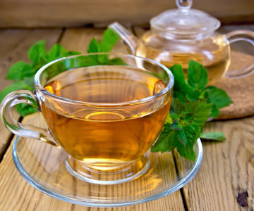 Tea with mint on wooden board