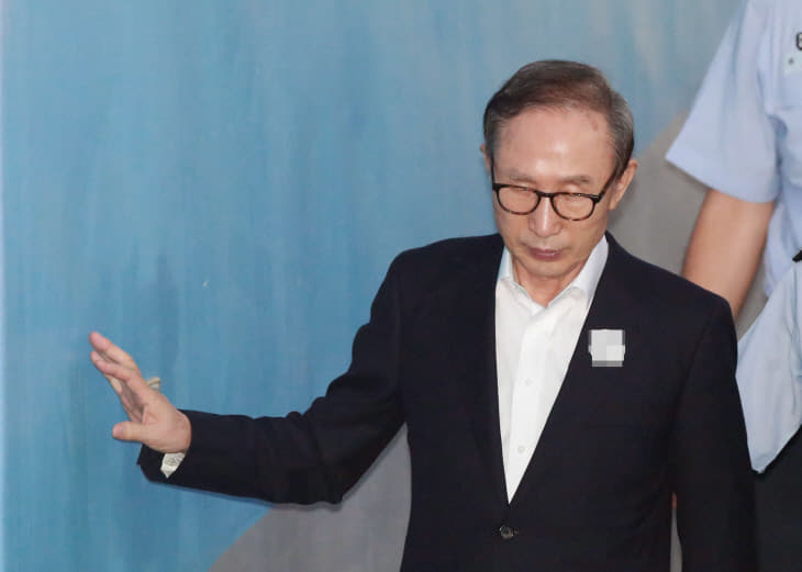 벽에 손대며 공판 출석하는 이명박<YONHAP NO-3350>