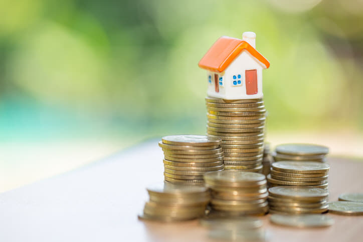 Mini house on stack of coins