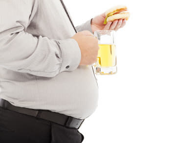 fat business man holding beer mug and hamburger