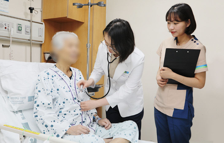 입원전담교수가 암병동에서 환자를 보살피고 있다f