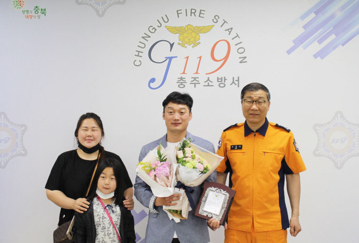 왼쪽부터 가족, 유공자 김정진, 이정구 충주소방서장