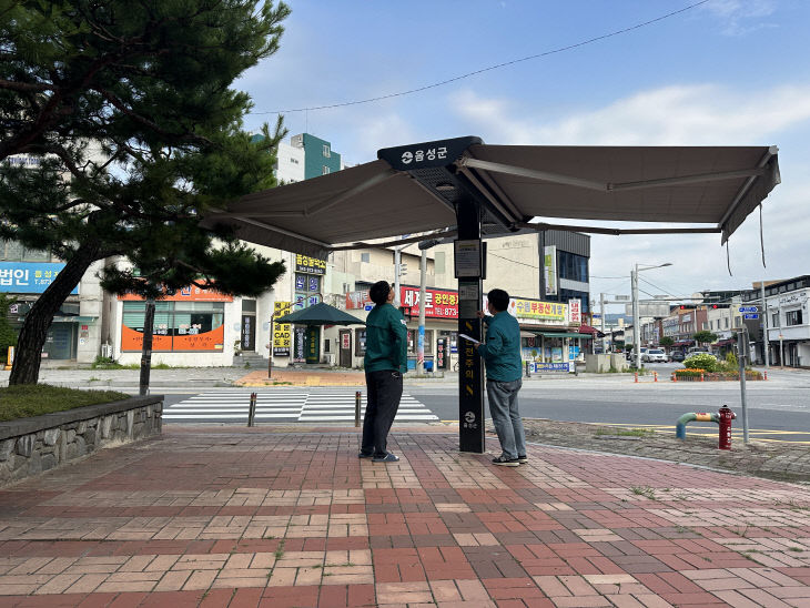 음성군 직원들이 횡단보도 앞에 설치된 스마트 그늘막을 점검하