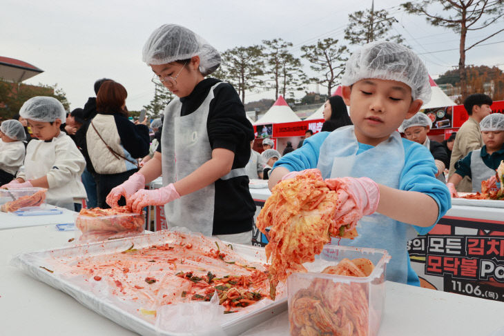 어린이 김장체험에서 완성된 배추김치를 용기에 옮겨 담는 모습