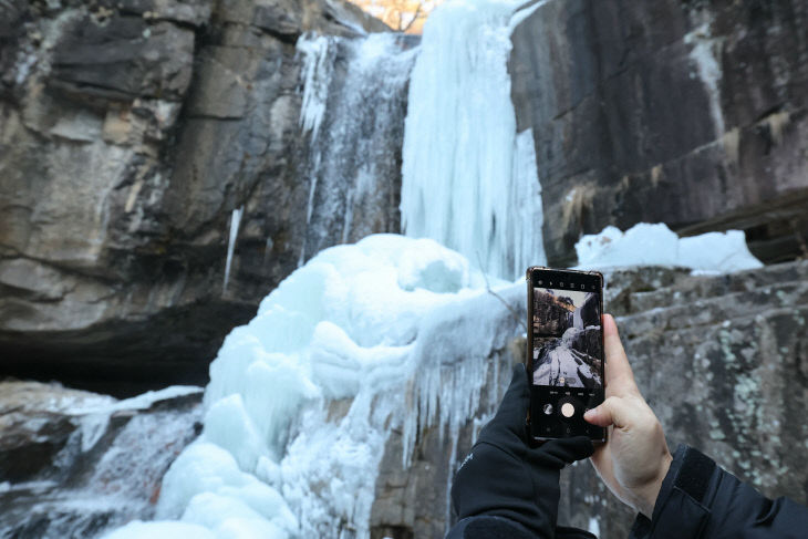 탐방객들이 얼음 폭포를 사진에 담고 있다. (1)