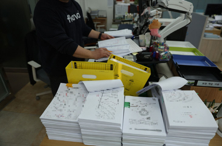 보도 1) 종이 서류를 처리하는 모습(2)