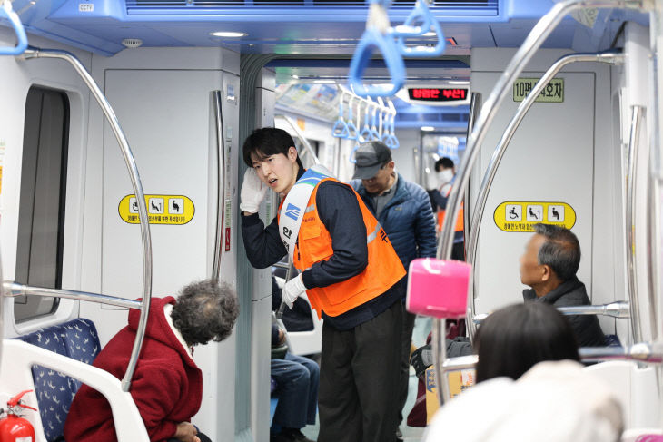 안전승무원이 열차 객실 중앙에서 시민들에게모습