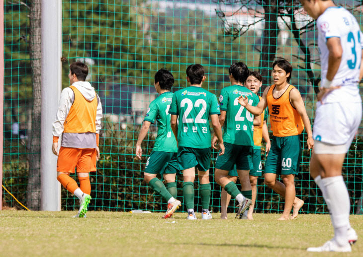 상대팀 선수뒤로 기뻐하는 제천시민축구단 선수들
